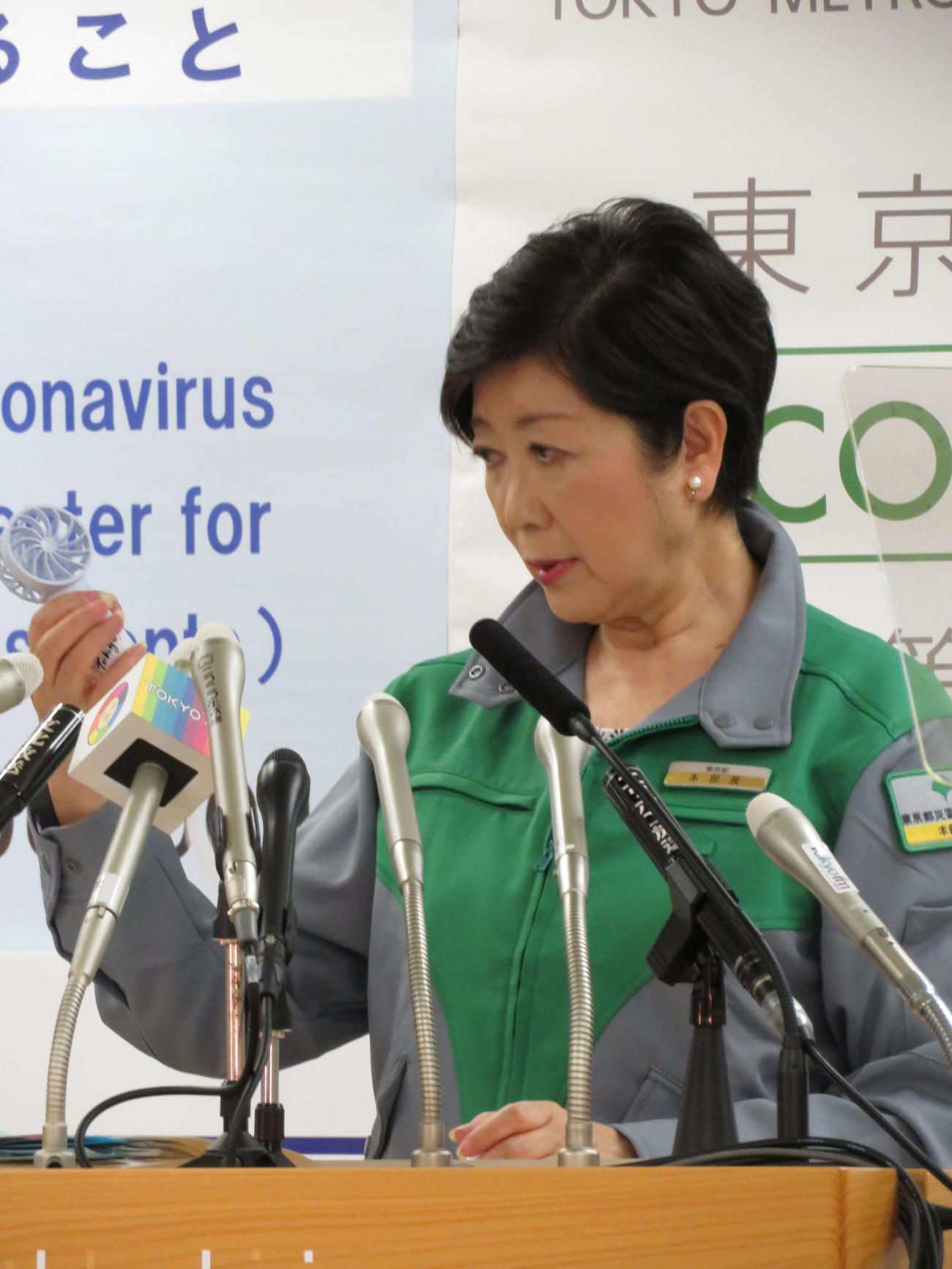定例会見で小型扇風機を持ち、暑さ対策の説明を行う東京都の小池百合子知事（撮影・近藤由美子）