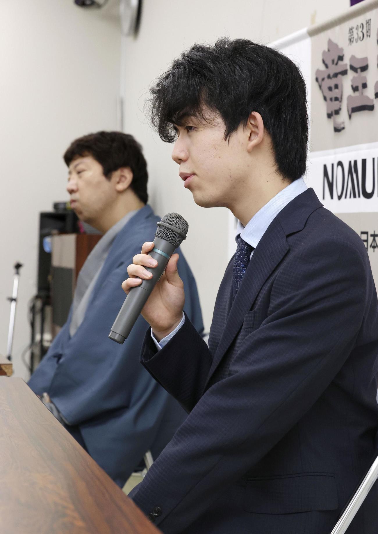 第33期竜王戦ランキング戦3組の決勝で、師匠の杉本昌隆八段（奥）に勝利し、記者会見する藤井聡太七段（共同）