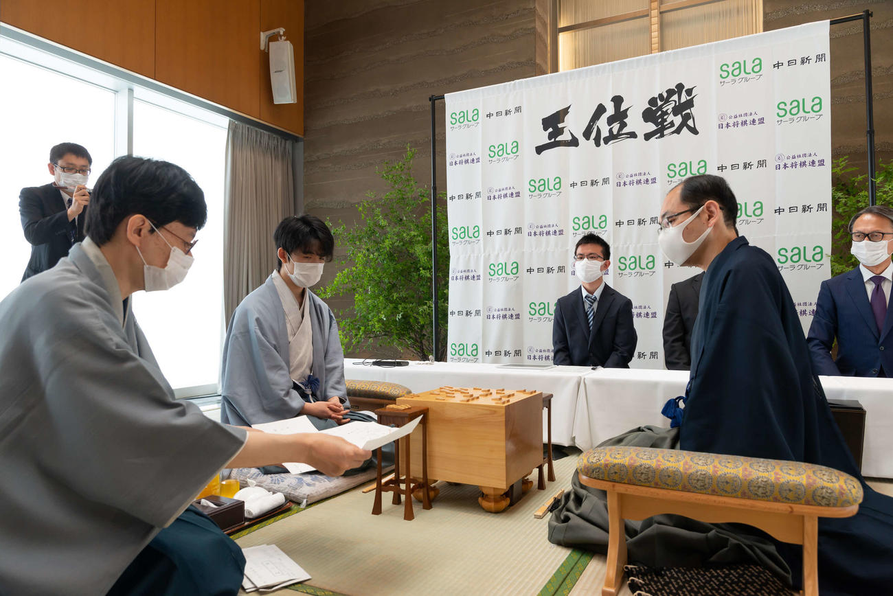 木村一基王位（右）の封じ手を読み上げる立会人の谷川浩司九段（日本将棋連盟提供）