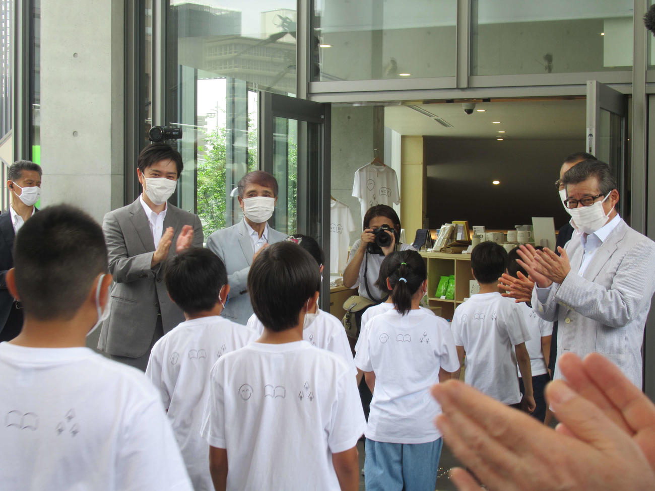 「こども本の森　中之島」の開館式に出席し、子どもたちの入館に拍手する左から吉村洋文知事、安藤忠雄氏。右は松井一郎市長（撮影・星名希実）