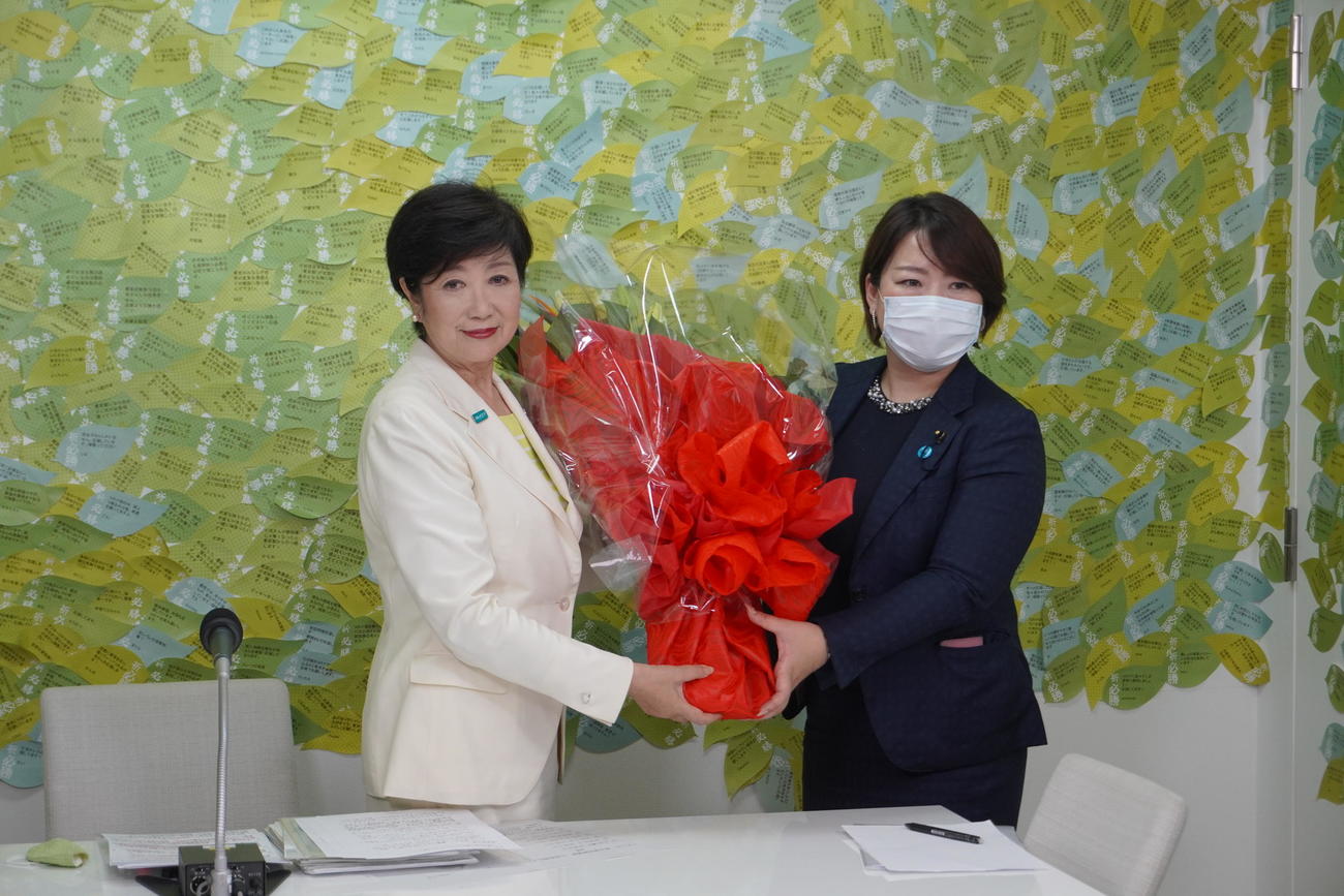 東京都知事選で再選を果たし、関係者から花束を受け取る小池百合子氏（左）