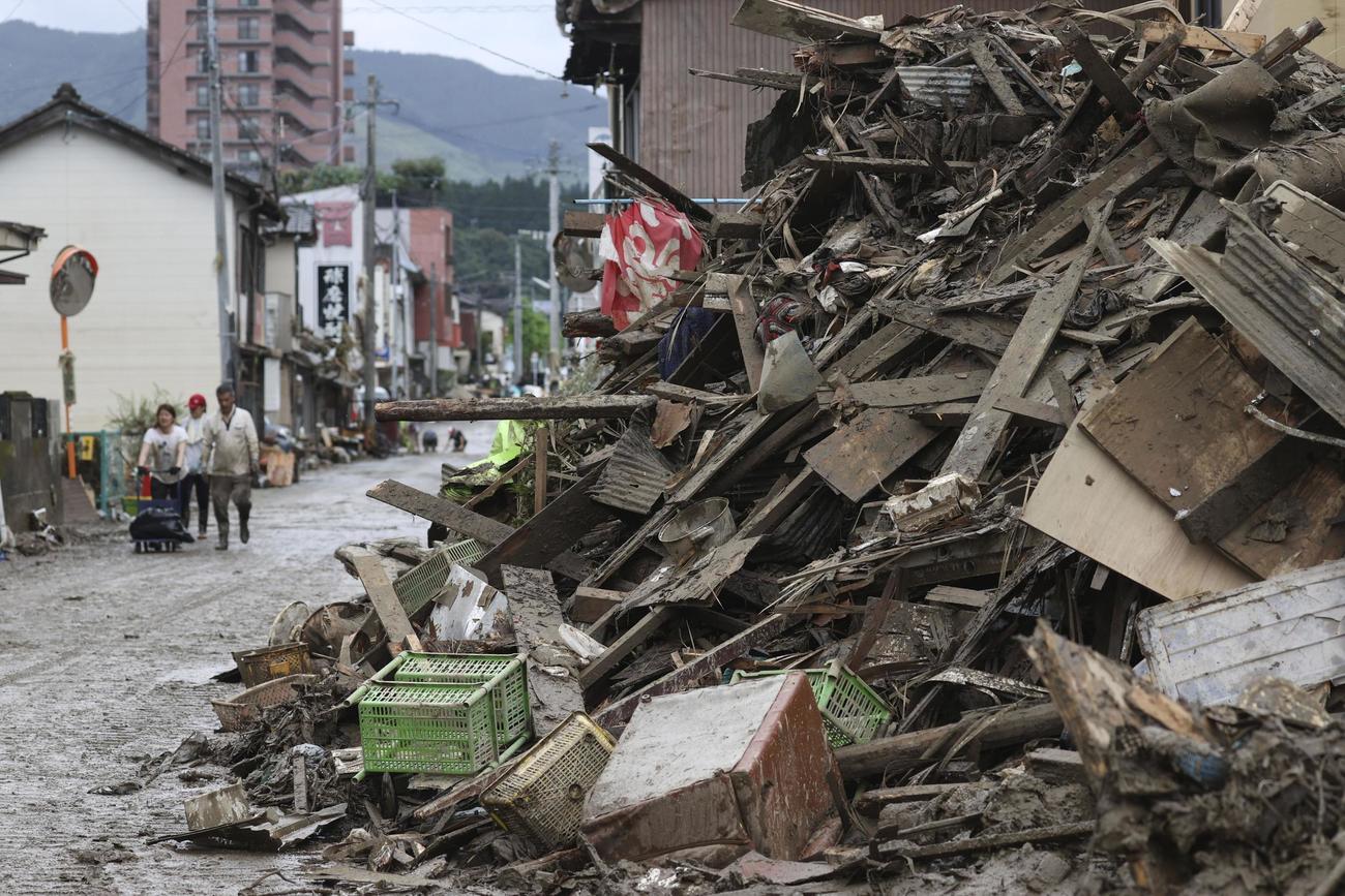 浸水被害のあった熊本県人吉市の市街地で、道路脇に積まれたがれき（共同）