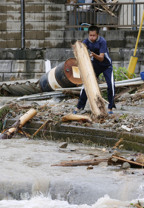熊本県津奈木町で、倒木を片付ける男性（共同）