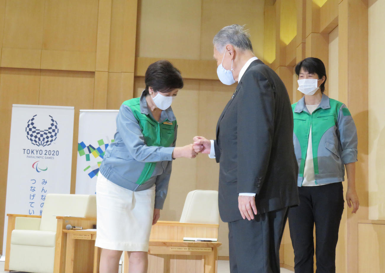 面会した東京五輪・パラリンピック組織委員会の森喜朗会長（中央）と小池百合子都知事はグータッチを交わす（撮影・佐藤勝亮）