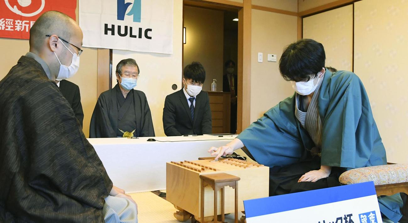第91期棋聖戦5番勝負の第3局で初手を指す藤井聡太七段（右）。左は渡辺明棋聖（代表撮影・共同）