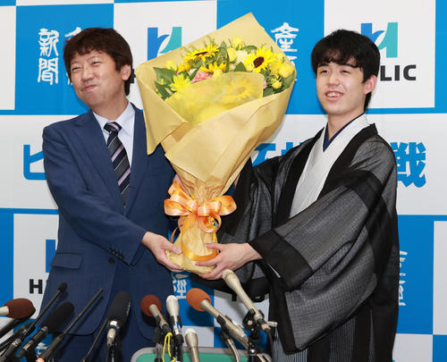 初タイトルを獲得し杉本昌隆八段（左）から花束を受け取る藤井聡太新棋聖（撮影・清水貴仁）