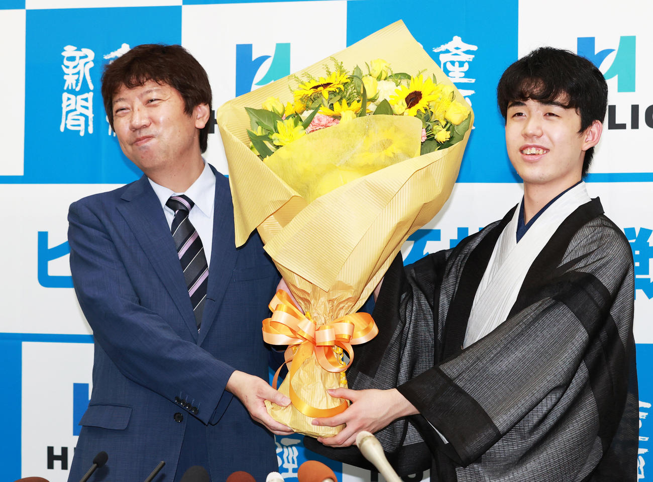 初タイトルを獲得し杉本昌隆八段（左）から花束を受け取る藤井聡太新棋聖（2020年7月16日撮影）