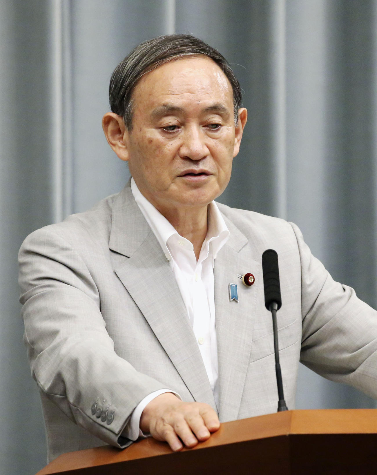 記者会見する菅官房長官（共同）