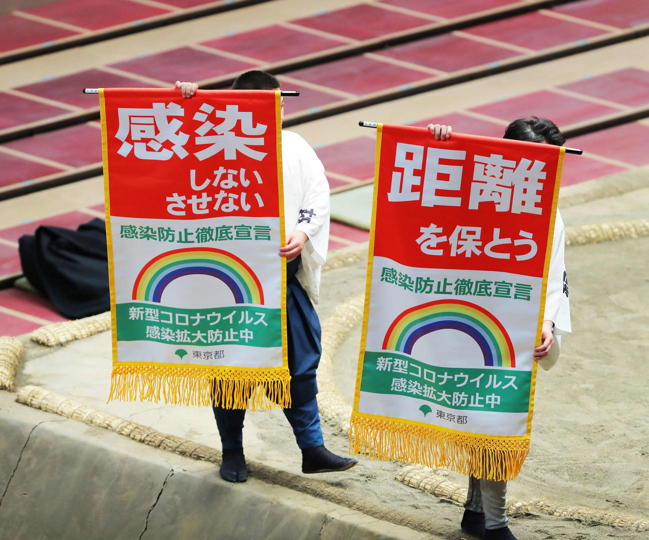 十両土俵入り後に土俵を回る、新型コロナ感染拡大防止を呼びかける懸賞旗スタイルの告知旗（撮影・河田真司）