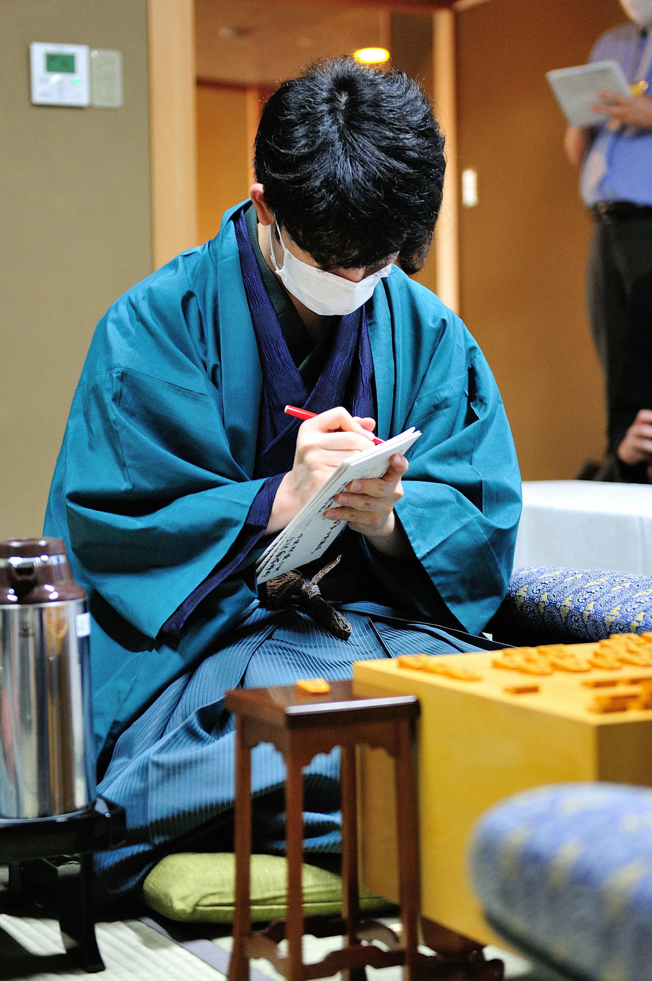 第61期王位戦7番勝負第3局の封じ手の封筒に署名をする藤井聡太棋聖（日本将棋連盟提供）