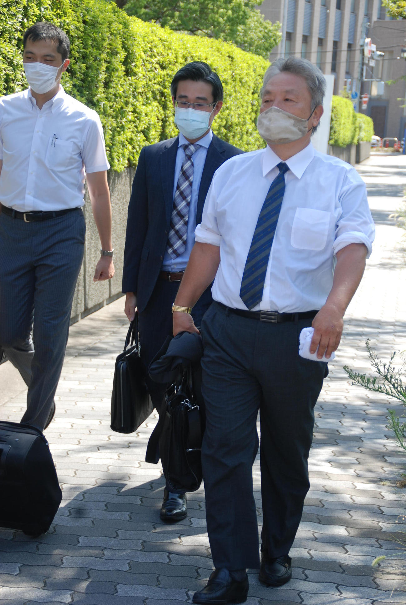 大阪地裁に代理人弁護士とともに入るセブン－イレブン東大阪南上小阪店の元オーナー松本実敏さん（右）（撮影・松浦隆司）