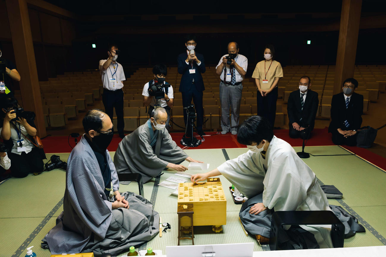 立会人の立会人は中田功八段が藤井の封じ手を開け「封じ手は後手8七同飛成です」と読み上げると、封じ手を指す（日本将棋連盟提供）