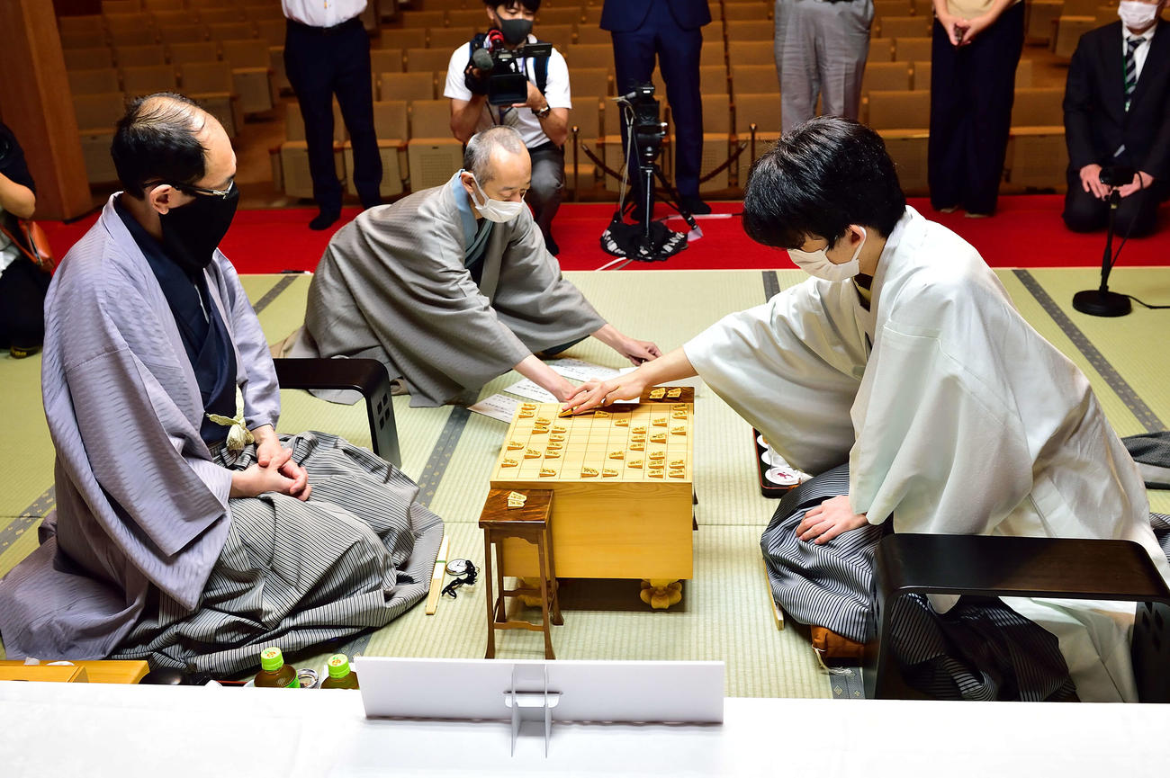 封じ手が開封されて後手8七同飛成と踏み込む藤井聡太棋聖（右）。左は木村一基王位（日本将棋連盟提供）