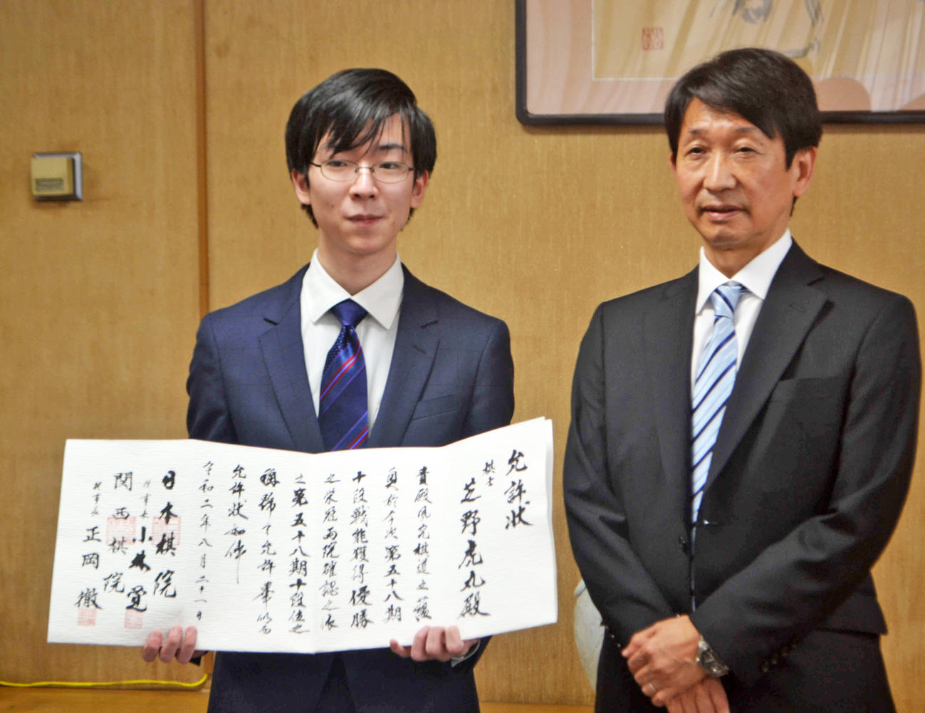 十段就位式で允許（いんきょ）状を手にする芝野虎丸十段（左）と日本棋院・小林覚理事長（撮影・赤塚辰浩）