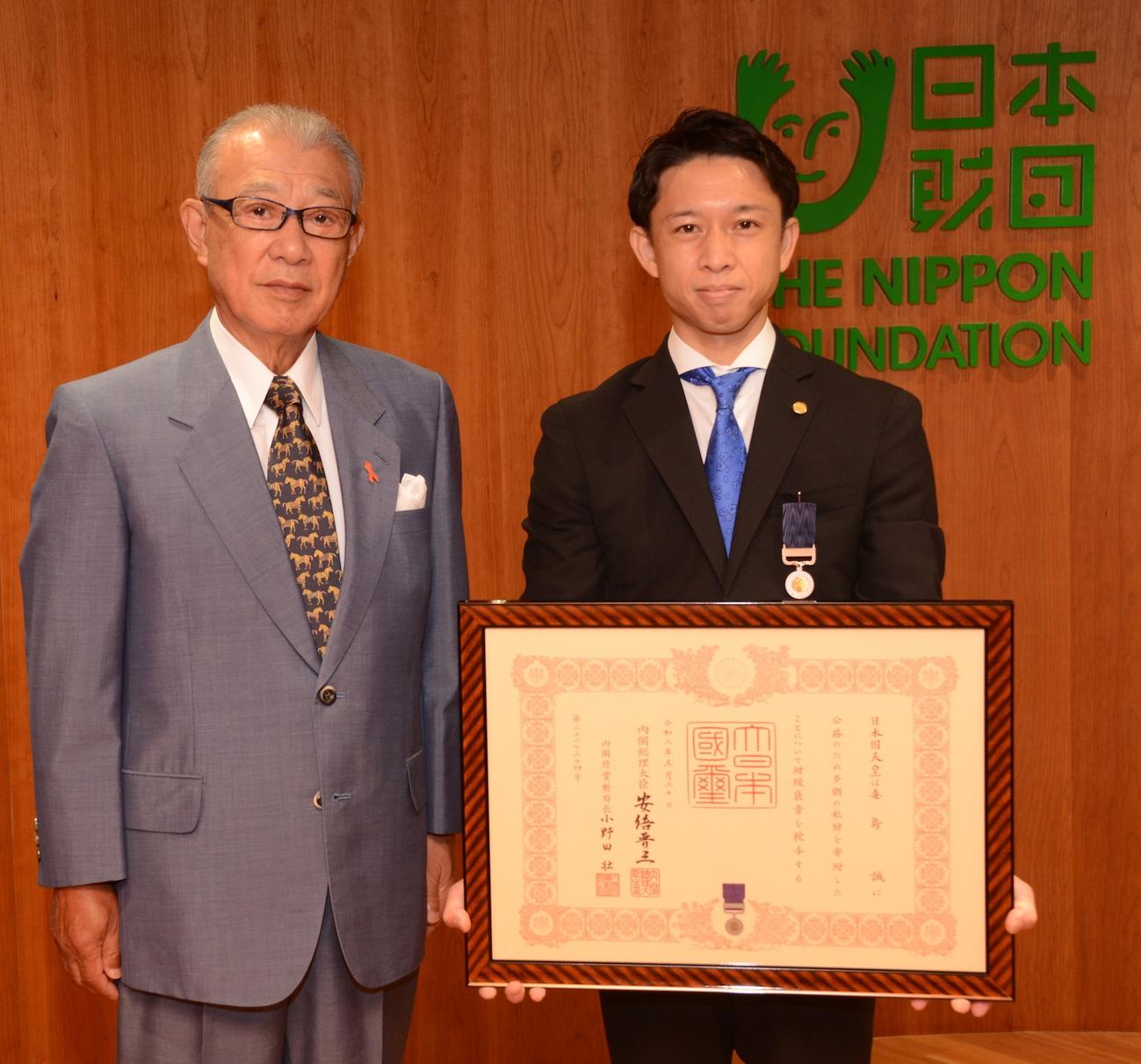 日本財団笹川陽平会長（左）から紺綬褒章が伝達された毒島誠