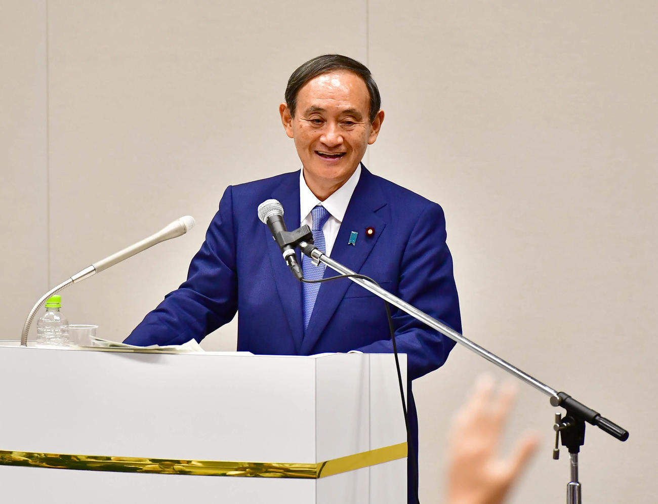自民党総裁選への出馬を表面した記者会見で報道陣からの厳しい質問に苦笑いを浮かべる菅官房長官（撮影・小沢裕）
