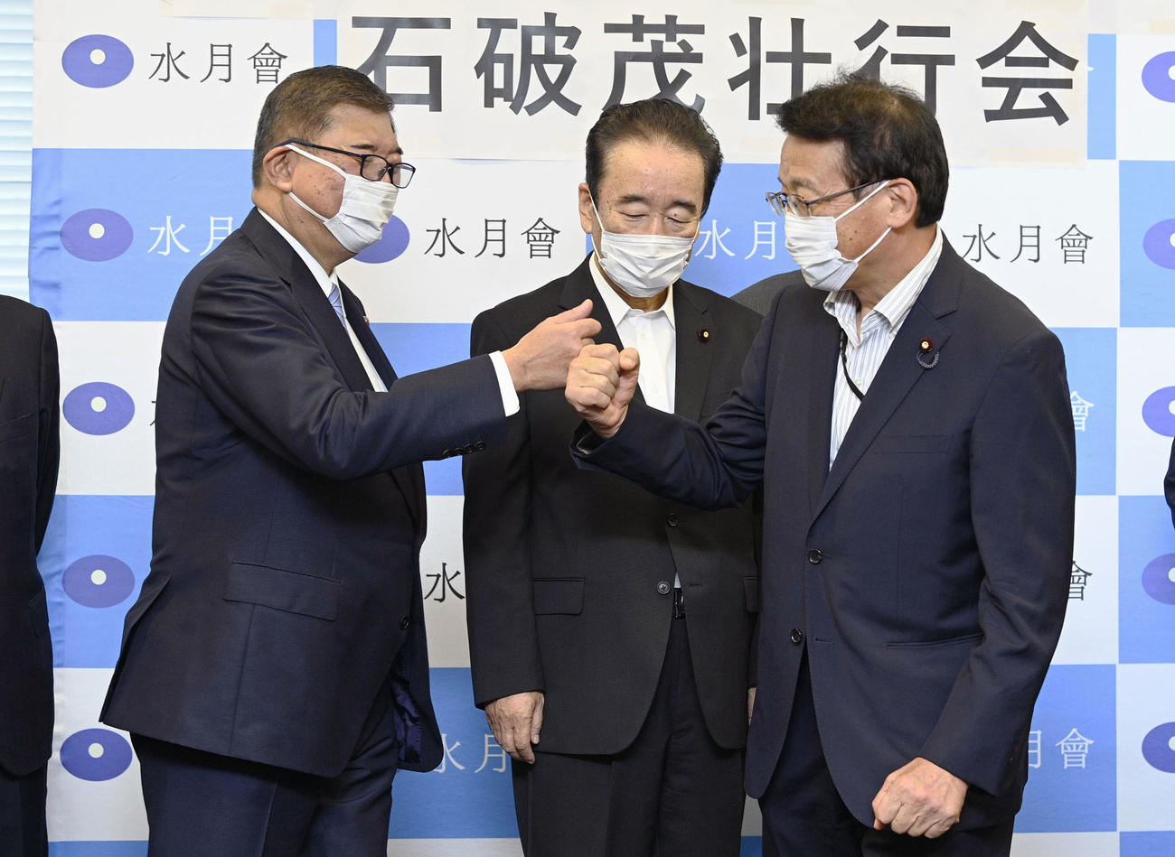 自民党総裁選を前に行われた決起集会でタッチする石破元幹事長（左）（共同）
