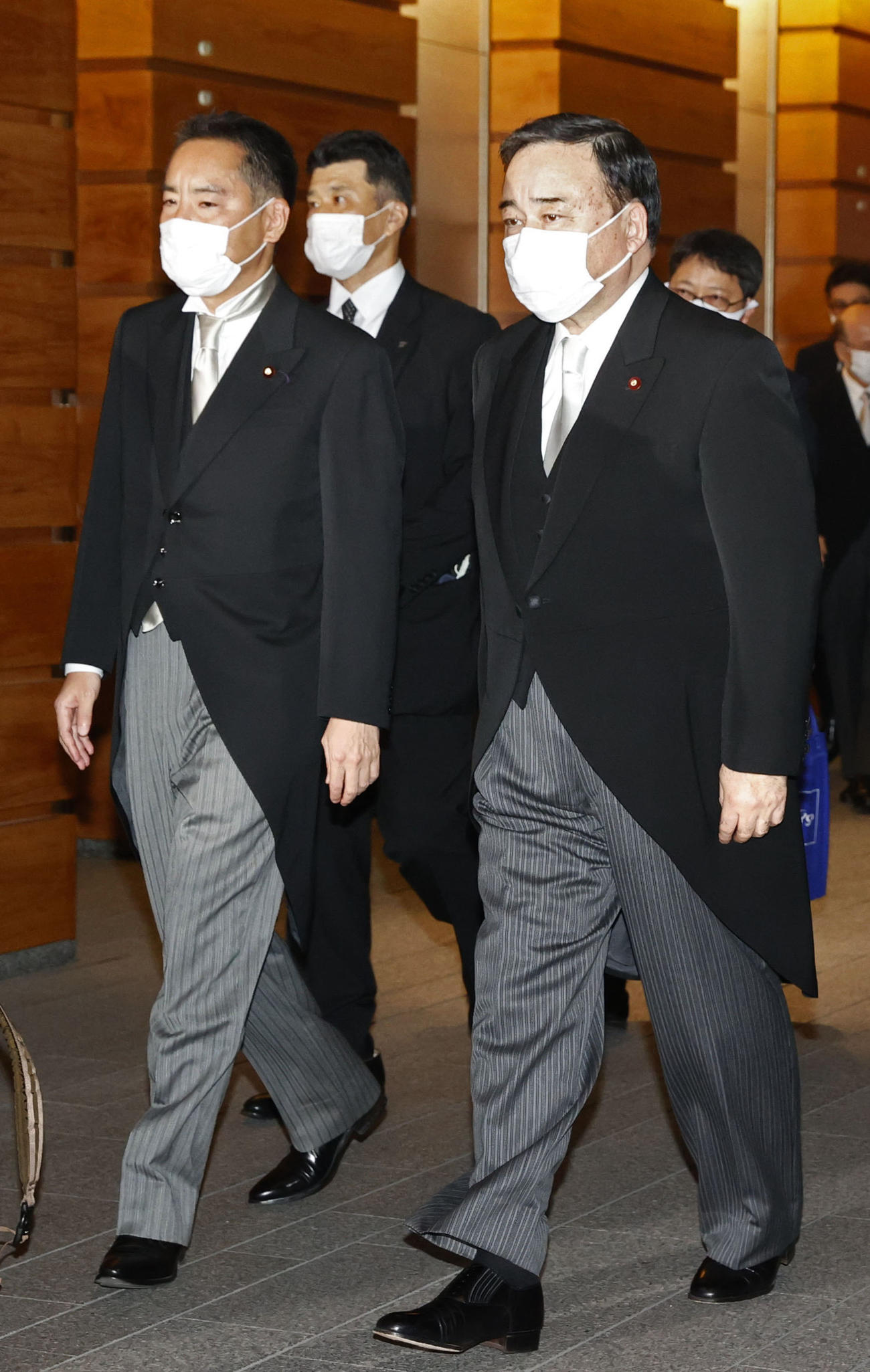 皇居での認証式のため首相官邸を出る梶山弘志経産相。左は井上信治万博相（共同）