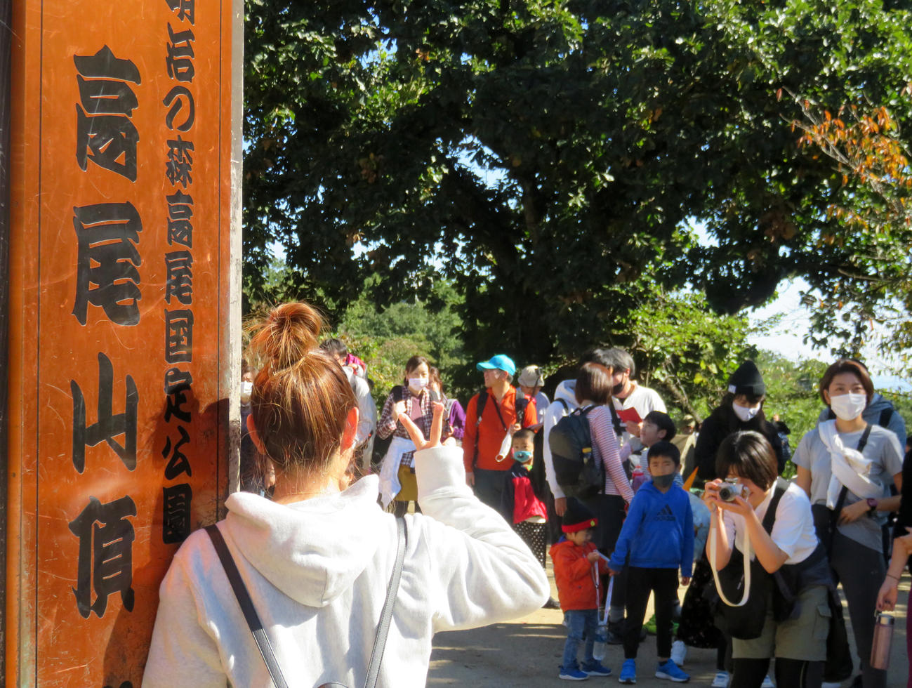 高尾山頂の標識の前には撮影順番待ちの行列ができた（撮影・中嶋文明）