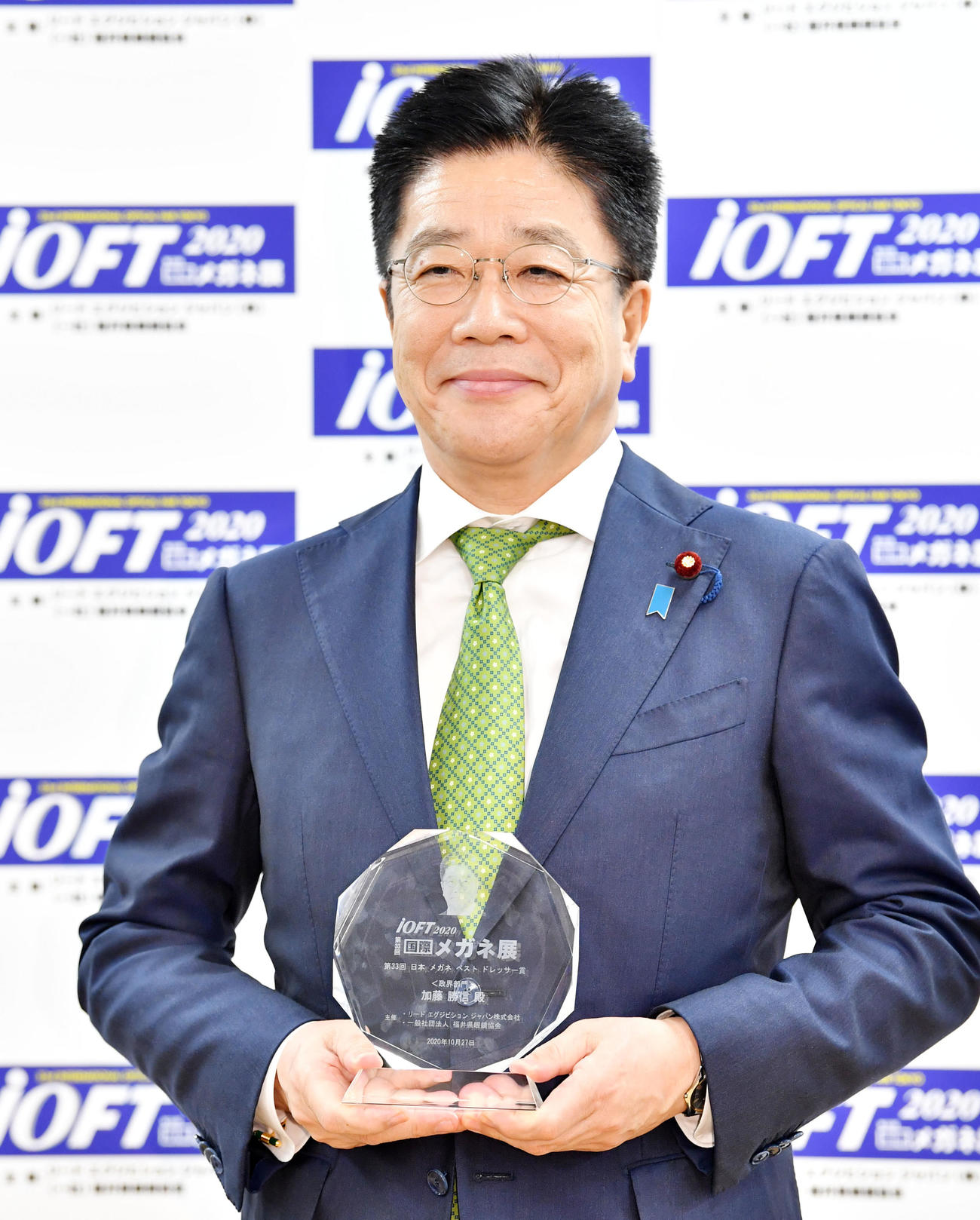 トロフィーを手に笑顔を見せる加藤勝信内閣官房長官（撮影・横山健太）