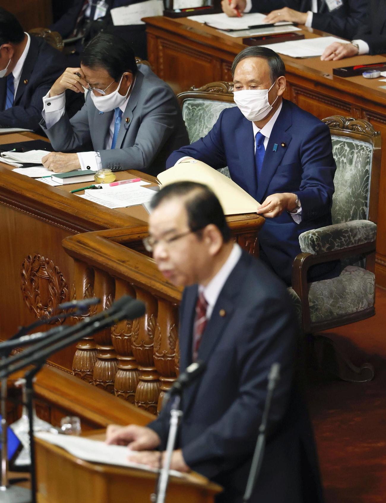 衆院本会議で共産党の志位委員長（手前）の代表質問を聞く菅首相（共同）