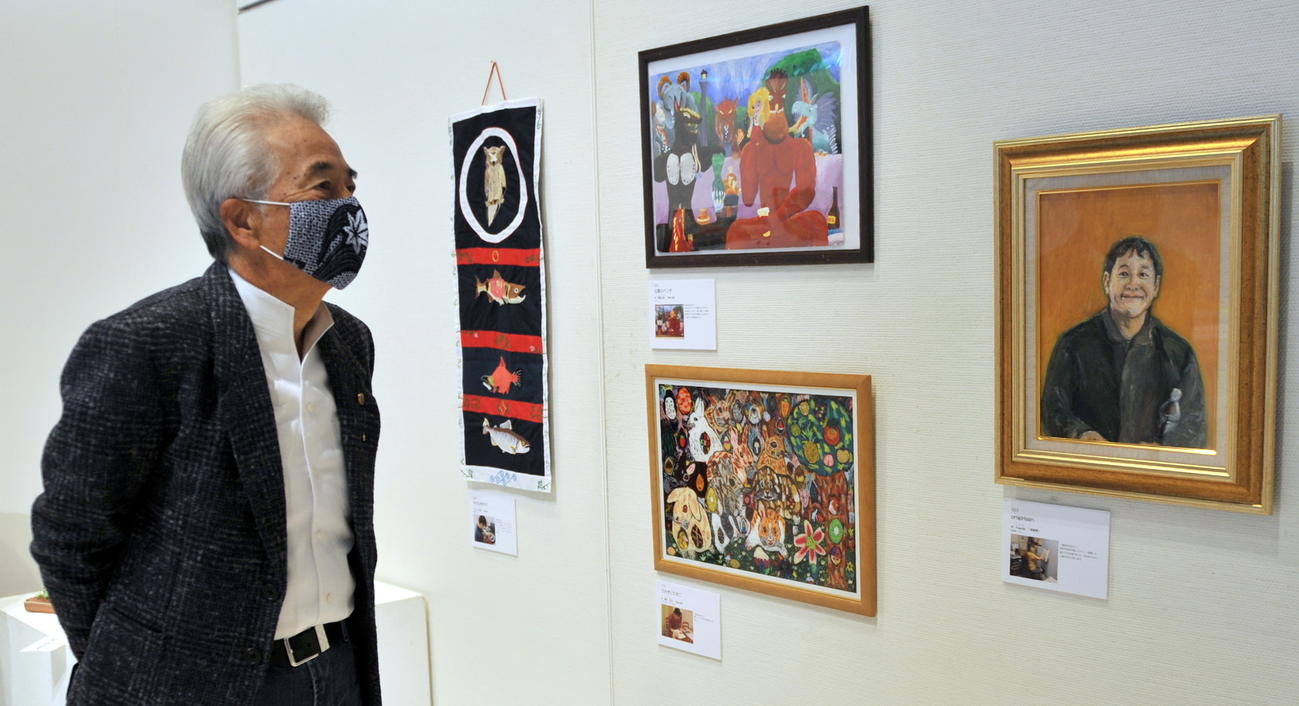 「東北障がい者芸術全国公募展」の開会式にゲスト参加した歌手さとう宗幸は熱心に作品を鑑賞