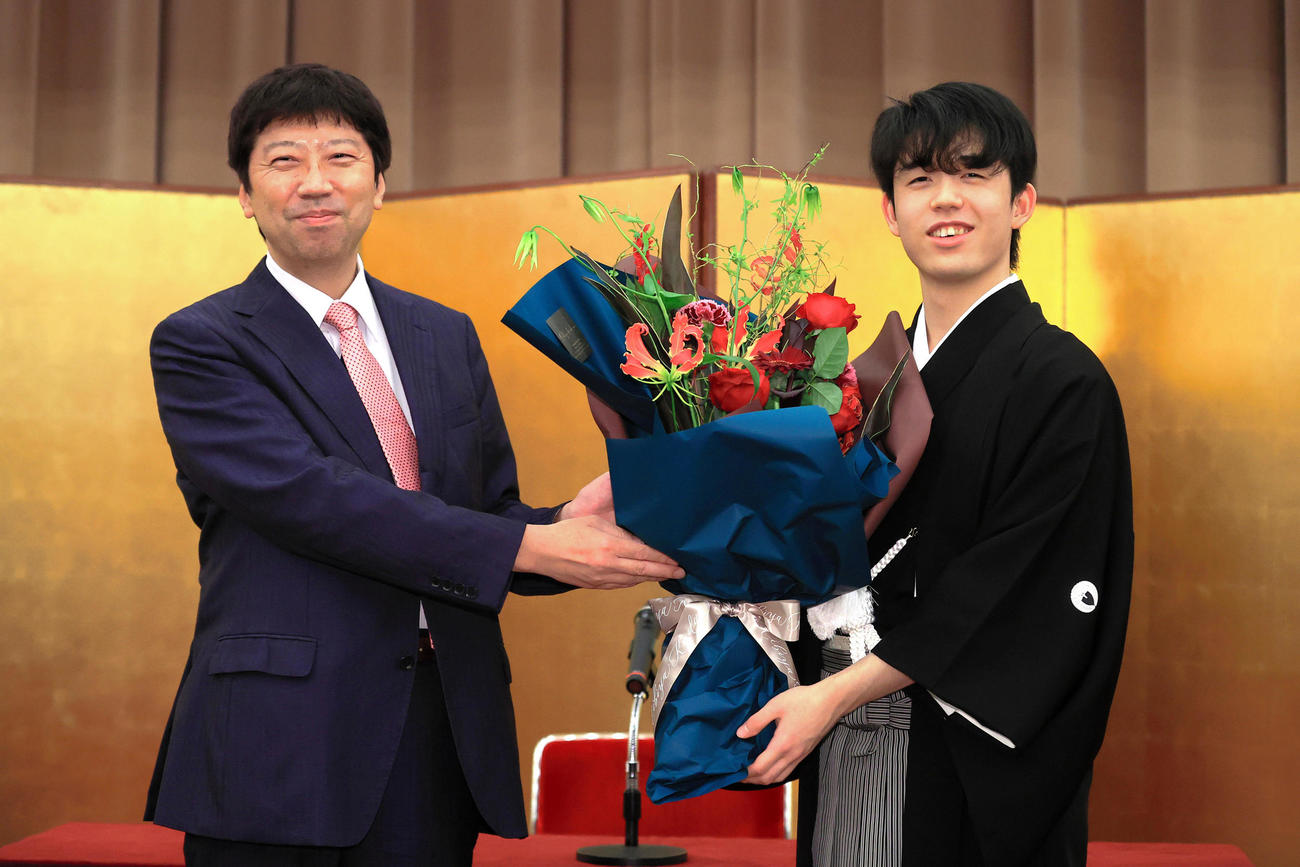 藤井王位就任式　師匠・杉本昌隆八段（左）から花束を受け取る藤井聡太王位（代表撮影）