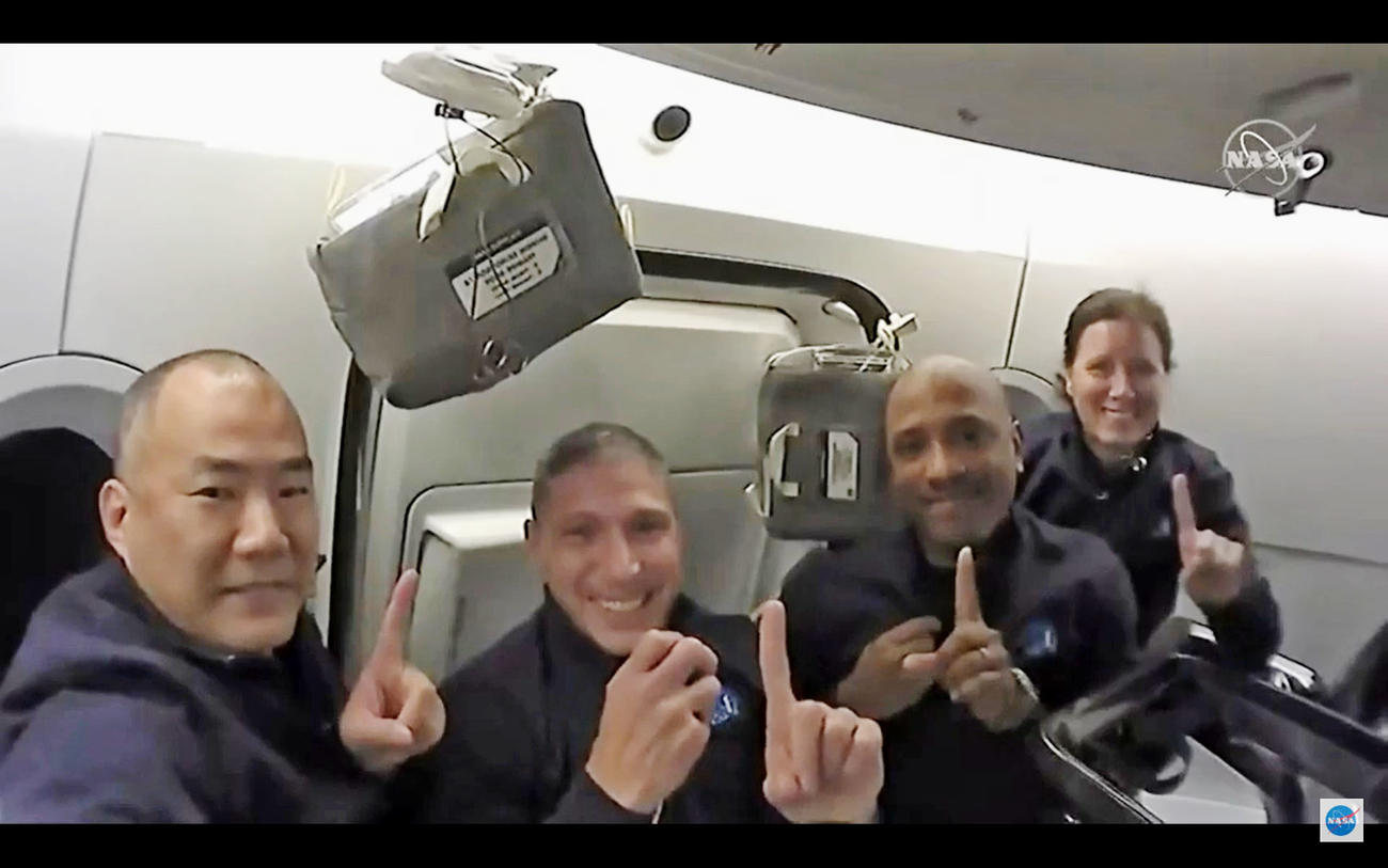 16日、飛行中の新型宇宙船クルードラゴンの船内でポーズをとる野口聡一さん（左端）ら（NASAテレビから・共同）
