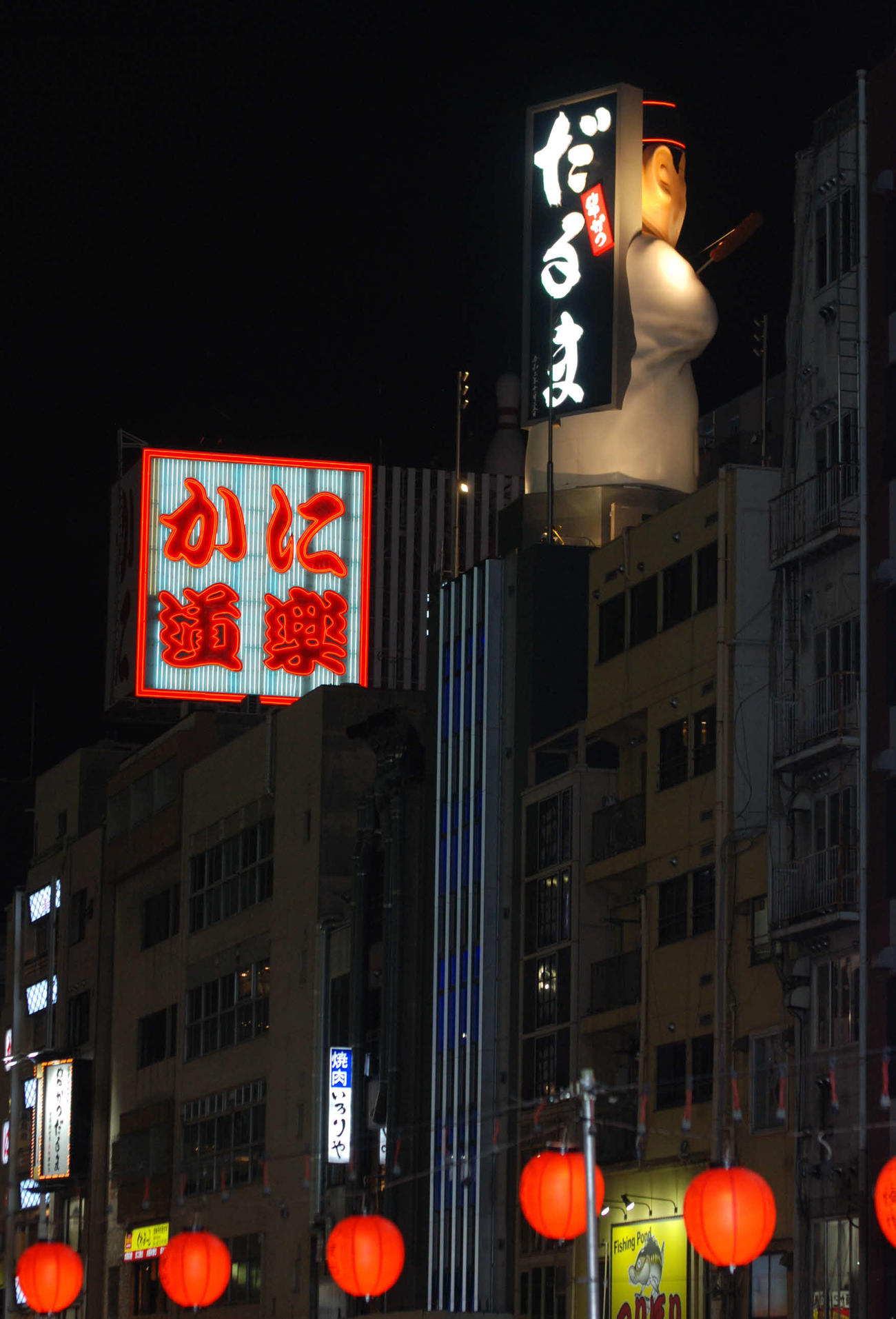 「だるま大臣像」が道頓堀・戎橋に背中を向けると看板が見える仕掛け（撮影・松浦隆司）