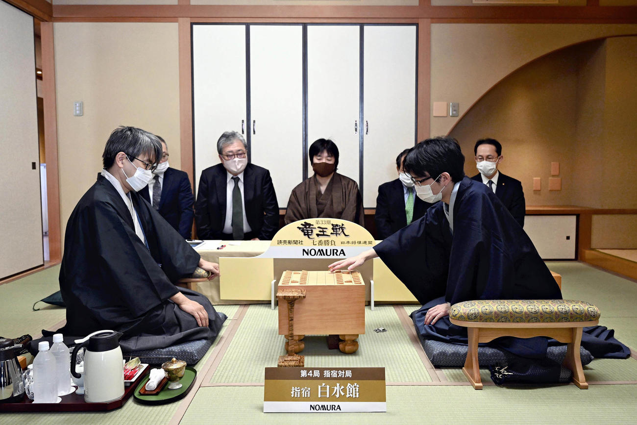 第33期竜王戦七番勝負第4局　初手を指す豊島将之竜王（手前右）と羽生善治九段（左）（代表撮影）