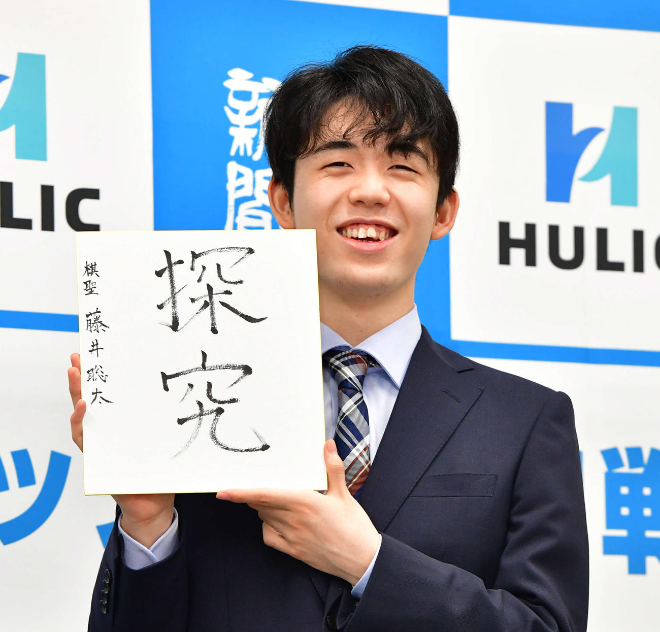 7月17日、初タイトル獲得から一夜明け、「探究」と書いた色紙を手に笑顔を見せる藤井聡太新棋聖