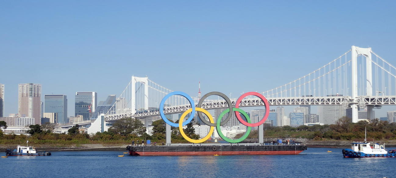 ボートに引っ張られて海路で輸送される五輪シンボル（撮影・鎌田直秀）