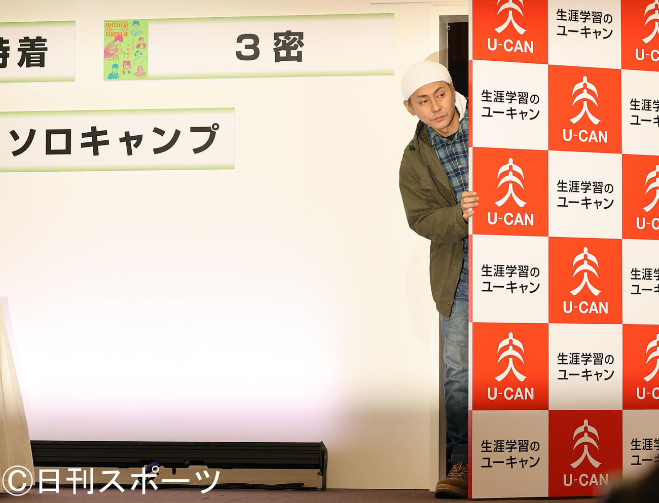 「新語・流行語大賞」発表のトップテンに選ばれた「ソロキャンプ」で、扉からのぞくヒロシ（撮影・浅見桂子）
