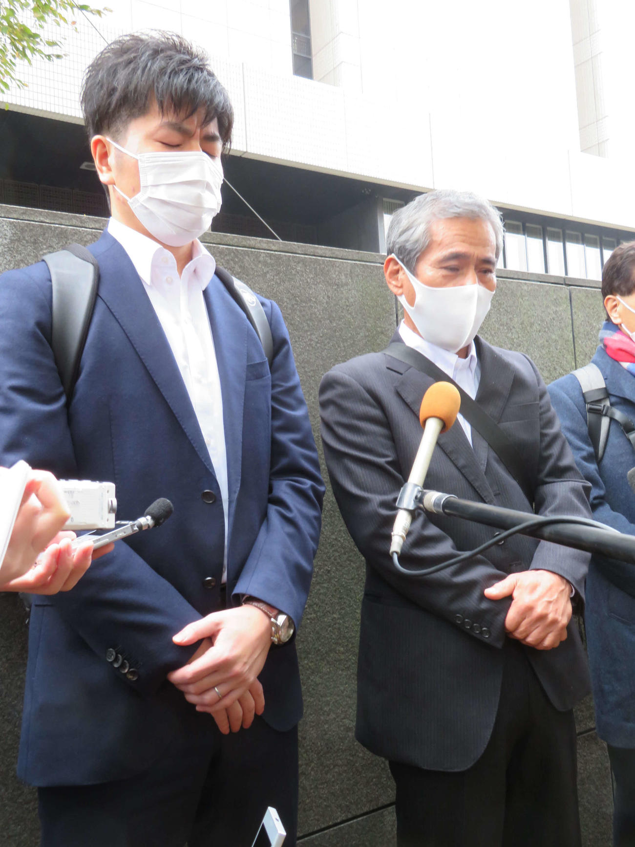 公判後、囲み取材に応じた松永拓也さん（左）と涙する義父の上原義教さん（撮影・村上幸将）