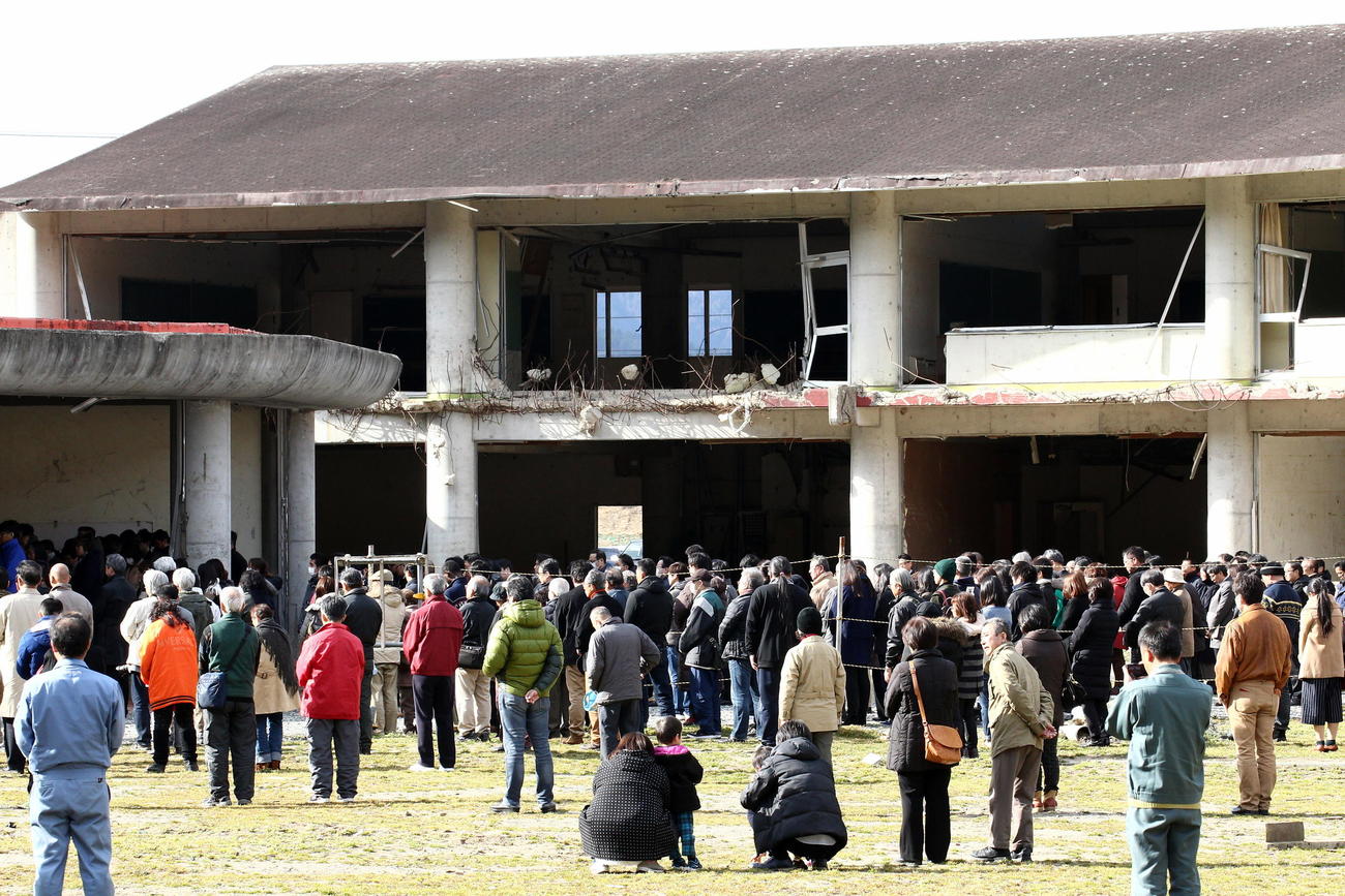 東日本大震災から丸5年を迎えた3月11日午後2時46分、大川小学校で黙とうする遺族や関係者（2016年3月11日撮影）