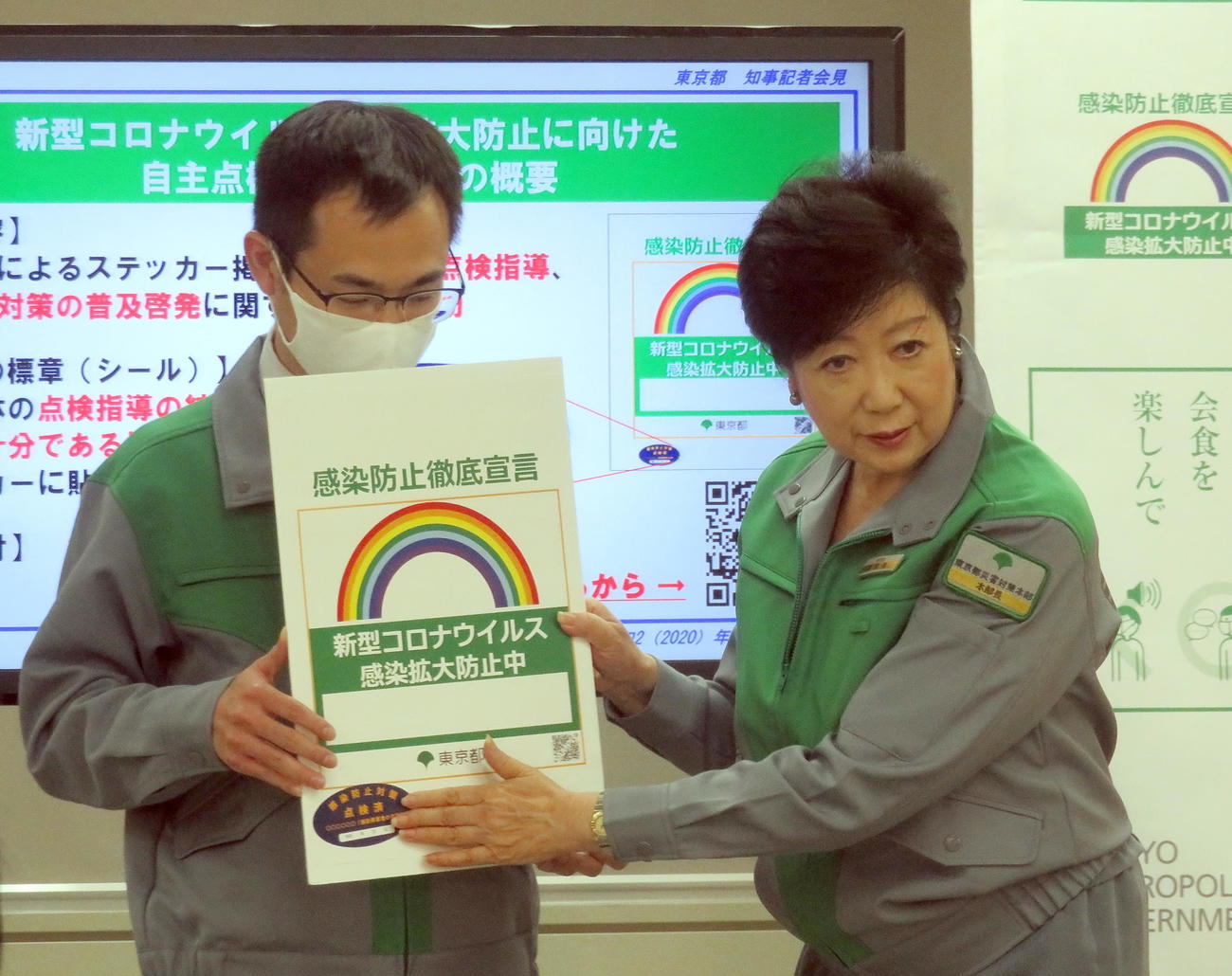 定例会見でコロナ感染防止徹底宣言ステッカーに点検済シールを貼る実演を行う小池都知事（右）（撮影・鎌田直秀）