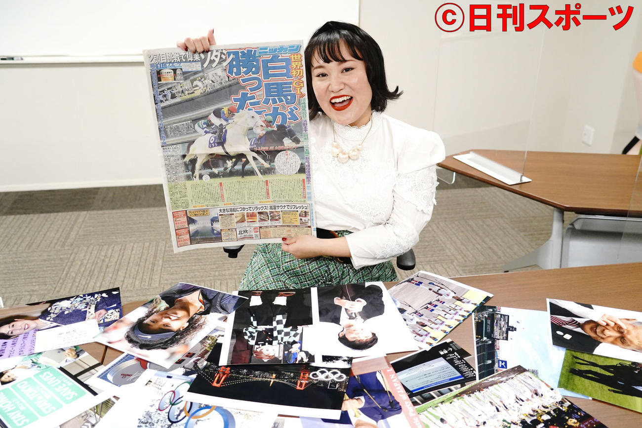 今年のニュースの写真を前に、白馬G1優勝紙面を手にするお笑いコンビ、フォーリンラブのバービー（撮影・佐藤成）