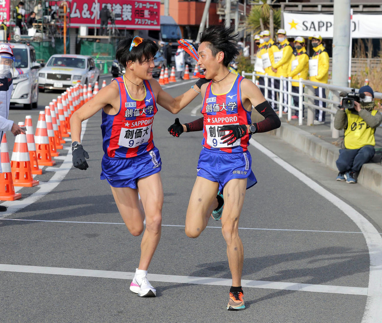 平塚中継所1位でタスキをつなぐ創価大7区の原富（右）と8区の永井（代表撮影）