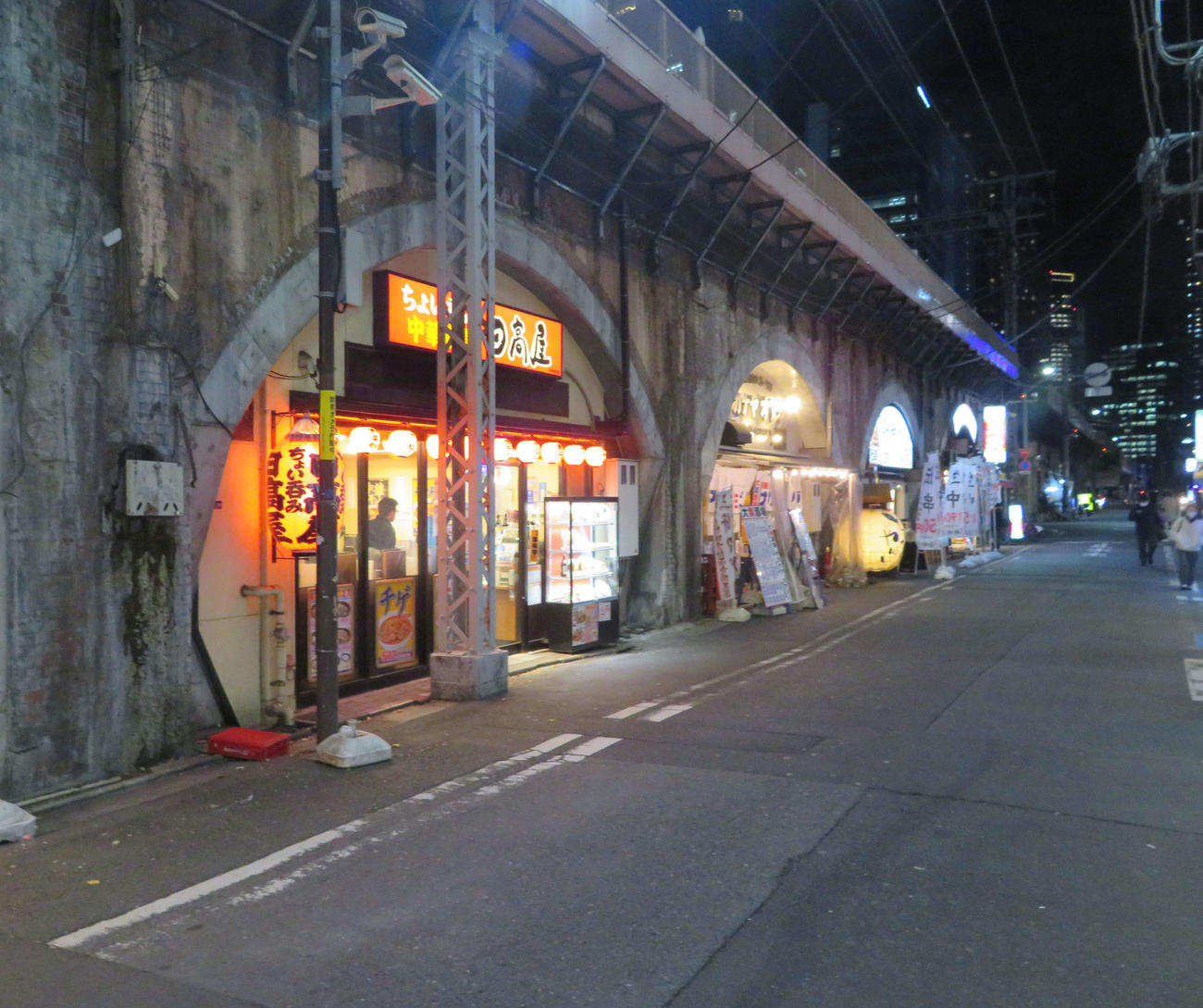 人通りが少ない新橋駅高架下の飲食店が並ぶ通り（撮影・沢田直人）