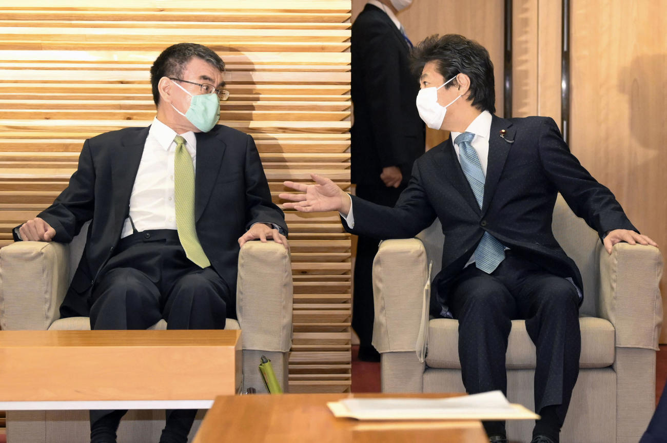 閣議前に言葉を交わす河野行革相（左）と田村厚労相（共同）