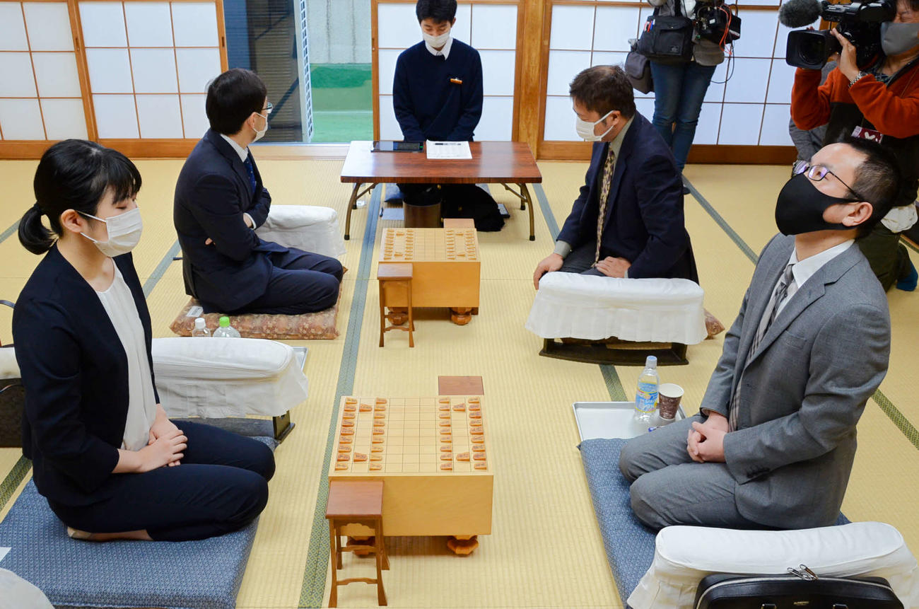 棋聖戦2次予選決勝で屋敷伸之九段（手前右）に挑む西山朋佳女流3冠（同左）（日本将棋連盟提供）