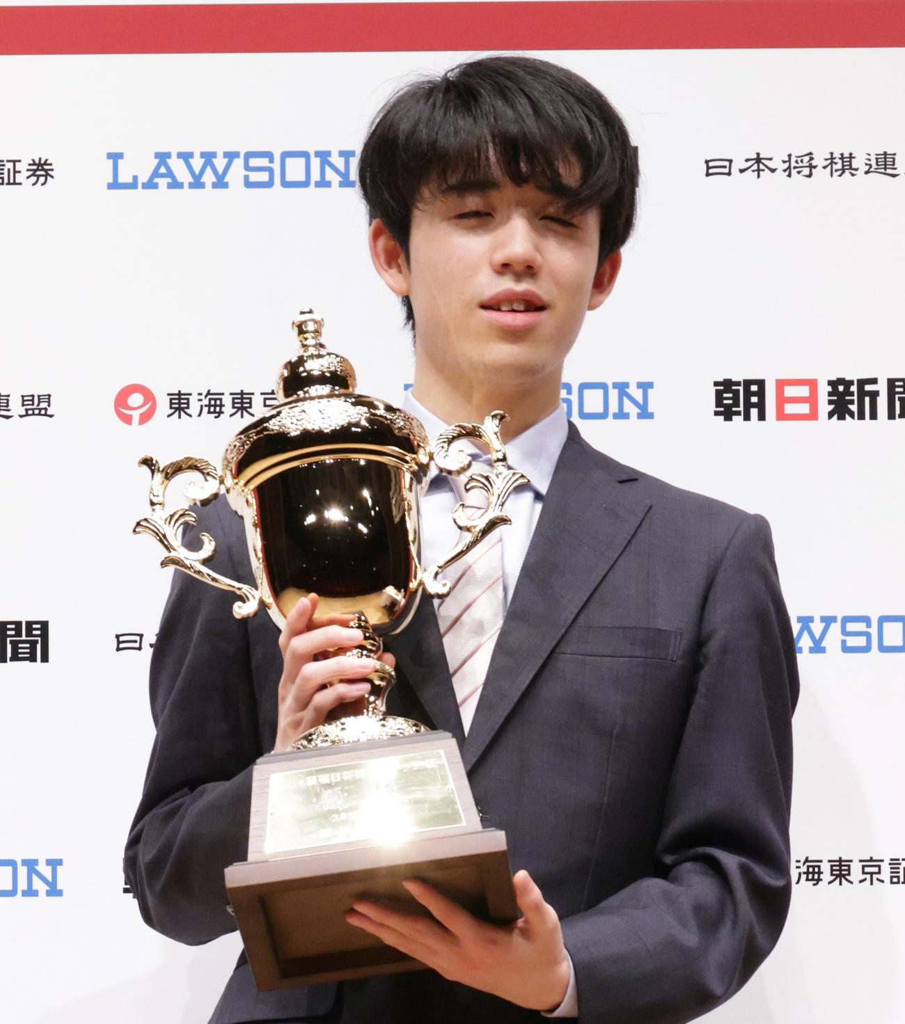 朝日杯優勝トロフィーを掲げる藤井聡太2冠（撮影・中島郁夫）