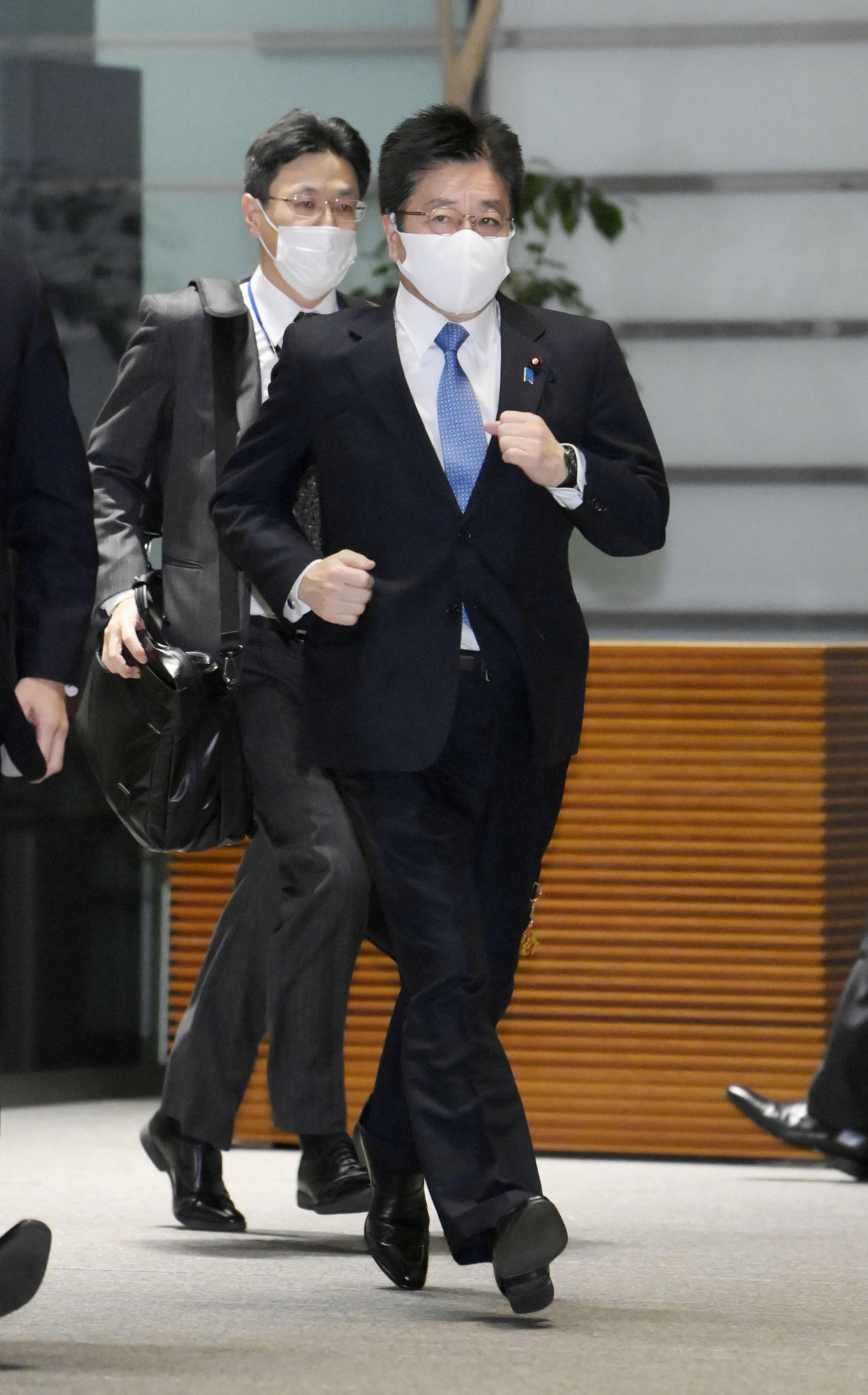 地震の一報を受け、首相官邸に駆け込む加藤官房長官＝13日午後11時38分