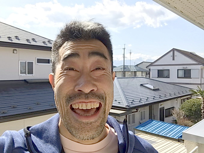 福島市の実家から晴天をバックに笑顔を見せるなすび（本人提供）