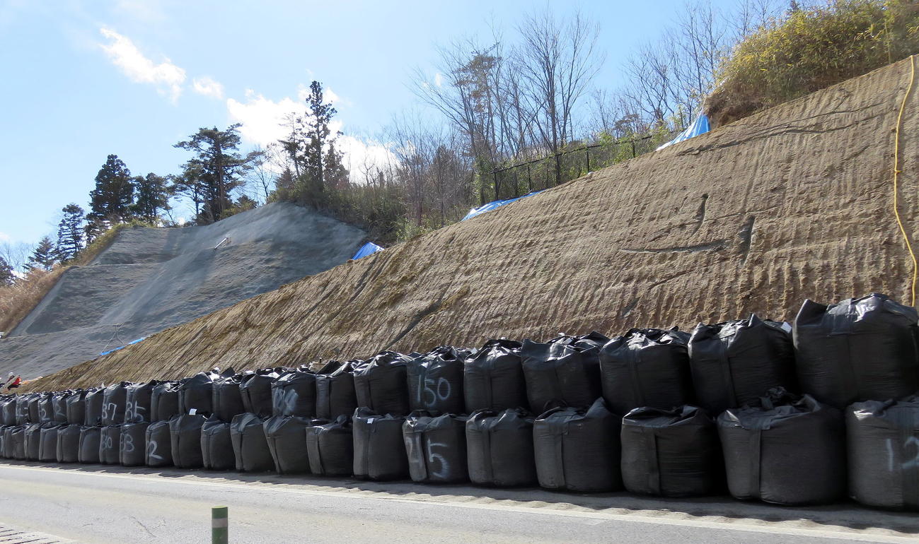 土のうやビニールシートで補修された常磐道の新地IC－相馬IC間で起きた土砂崩れ現場（撮影・鎌田直秀）