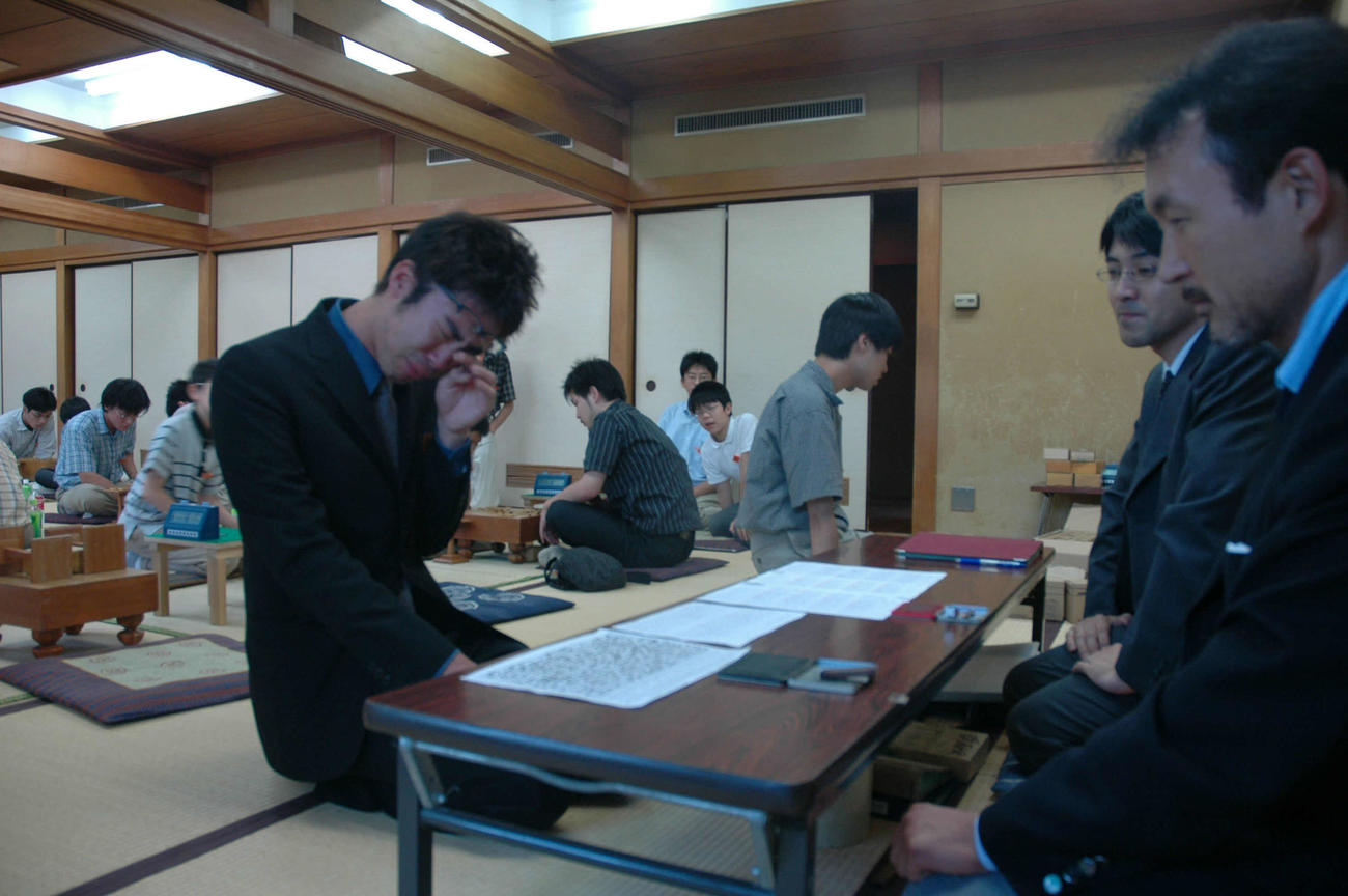 プロ入りを果たし号泣する遠山雄亮現六段。右から2人目は当時の奨励会幹事の中座真現七段、右は同中川大輔現八段（05年9月撮影）