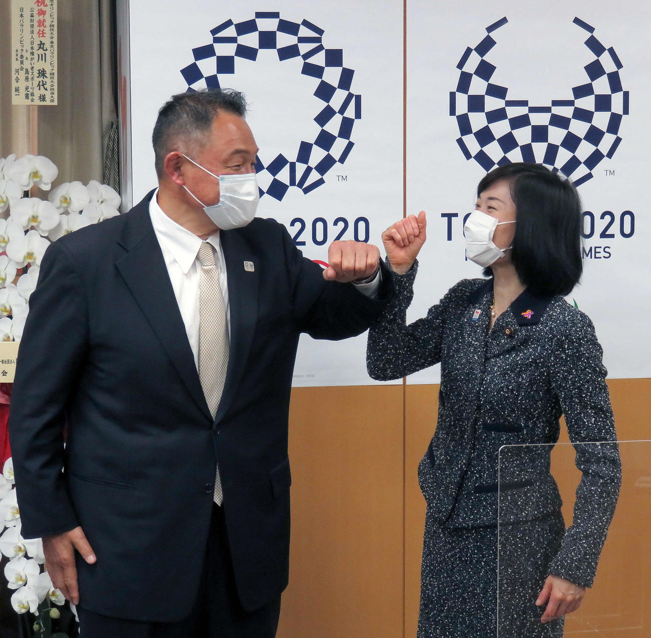 JOC山下会長（左）と笑顔で向き合いながら肘タッチを行う丸川五輪相（2021年2月24日撮影）