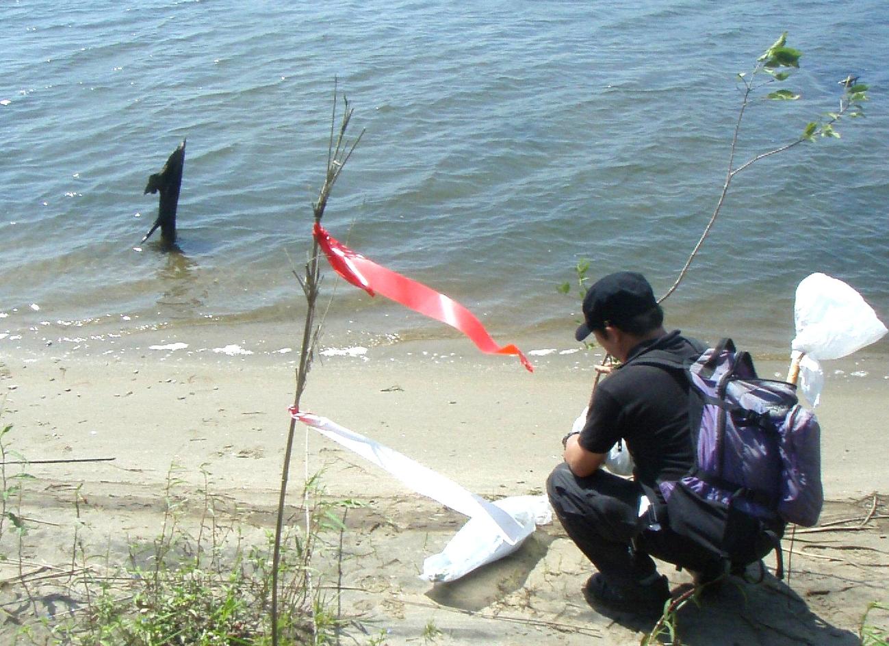 震災から1年後の2012年、葉子さんの遺体が見つかった請戸川で白川さんは手を合わせる