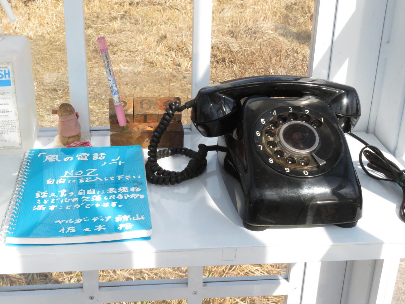 「風の電話」の内部。黒電話とノートなどが置かれている（撮影・近藤由美子）
