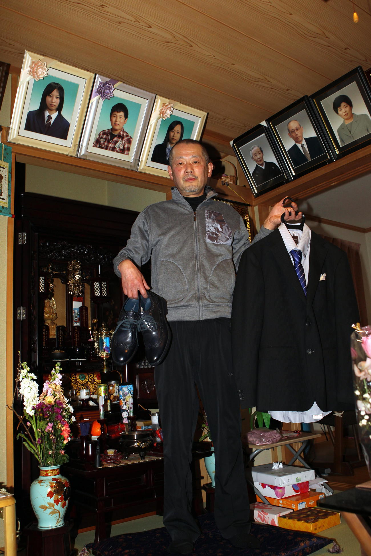 大輔くんの成人祝いで買ったスーツを手にする今野浩行さん（撮影・三須一紀）